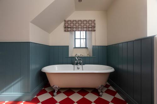 een bad in een groene badkamer met een raam bij Montagu in Thornhill