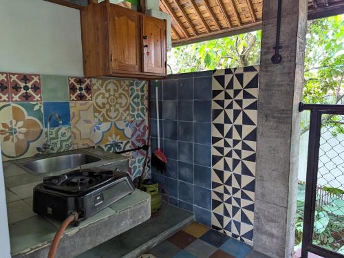 eine Küche mit Herd und Spüle in der Unterkunft Melati Double Studio with Shady Balcony Upstairs in Timuran