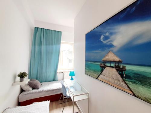 a living room with a large painting of a pier at Hostel 44 in Sopot