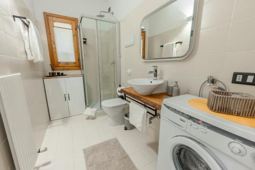 a bathroom with a sink toilet and a mirror at Dagi's Dolcevita Apartments in Colà di Lazise