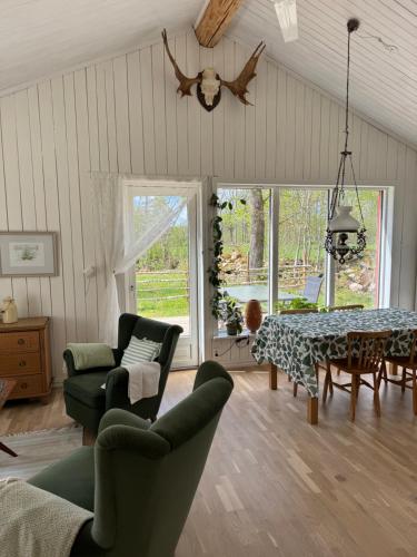 a living room with a table and chairs at Meadow house, a comfortable and modern home near a lake in Ljungby