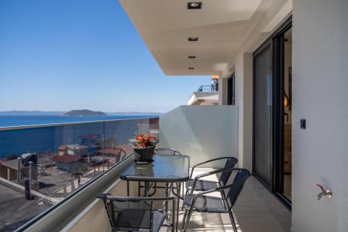 a balcony with a table and chairs and a view of the ocean at Aeli Vista Apartments in Neos Marmaras