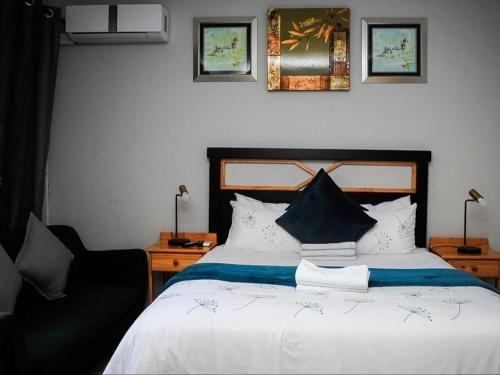 a bedroom with a large bed and a chair at 5@Partridge Guesthouse in Newcastle