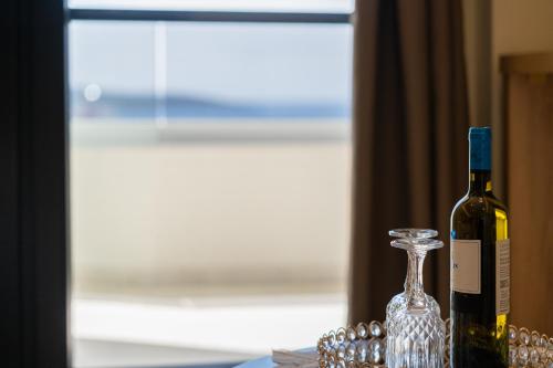 a bottle of wine sitting next to a glass vase at Aeli Vista Apartments in Neos Marmaras