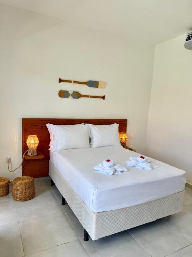 a bedroom with a white bed with two towels on it at Yahweh Hotel in São Miguel do Gostoso