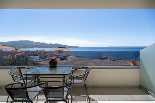 a table and chairs on a balcony with a view of the ocean at Aeli Vista Apartments in Neos Marmaras