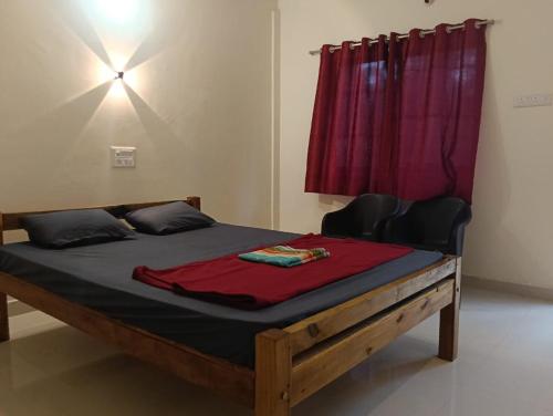 Un dormitorio con una cama con una cortina roja. en Shiva Moon Guest House, en Gokarna