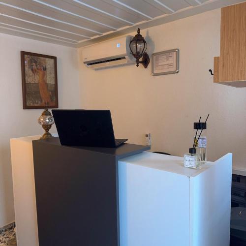 a desk with a laptop computer on top of it at Hera Pansiyon in Ayvalık