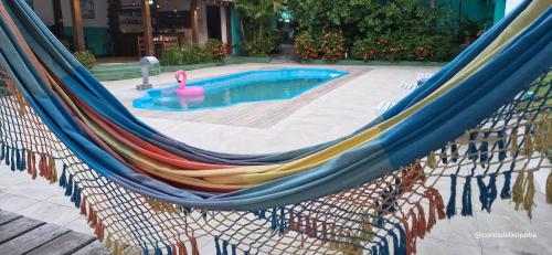 a hammock with a pool and a pink flamingo in it at Cores de Boipeba in Ilha de Boipeba