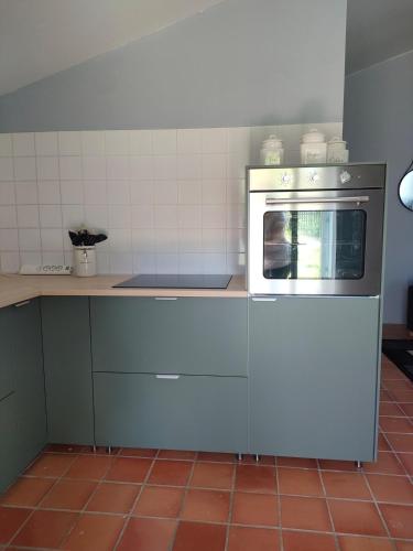 a kitchen with a microwave oven sitting on a counter at Les Murmures de Charente in Villiers-le-Roux