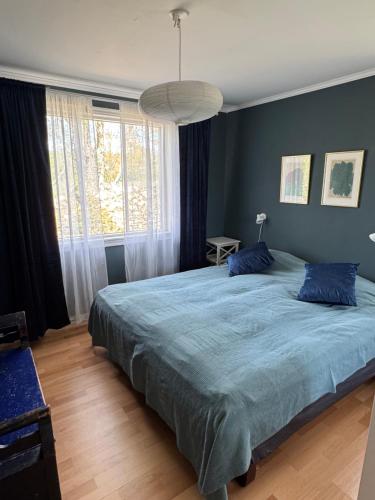 a bedroom with a large bed with blue sheets at Meadow house, a comfortable and modern home near a lake in Ljungby