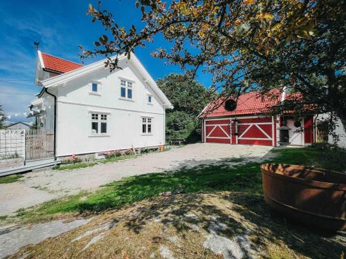 a large white house with a red barn at Unikt skipperhus med høner i hagen in Hvaler