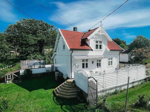 a white house with a fence in the yard at Unikt skipperhus med høner i hagen in Hvaler