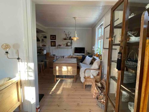 a living room with a couch and a table at Unikt skipperhus med høner i hagen in Hvaler