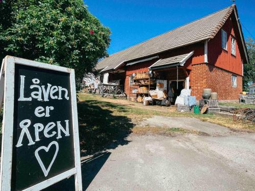 a sign in front of a building with a barn at Unikt skipperhus med høner i hagen in Hvaler
