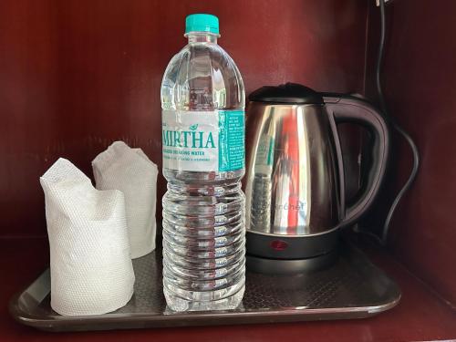 a bottle of water sitting on a tray with a tea kettle at Nature View Resort Yercaud in Yercaud