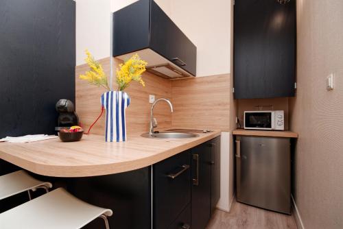 - une cuisine avec un comptoir en bois et un évier dans l'établissement Le Nouveau Franklin - Au pied de la plage, à Saint-Malo