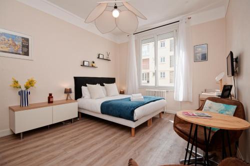 une chambre avec un lit et une table dans l'établissement Le Nouveau Franklin - Au pied de la plage, à Saint-Malo