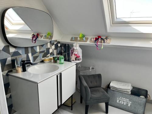 une salle de bain avec un lavabo, un miroir et une chaise dans l'établissement Colora Cottage - A 100 m de la plage, à Portbail