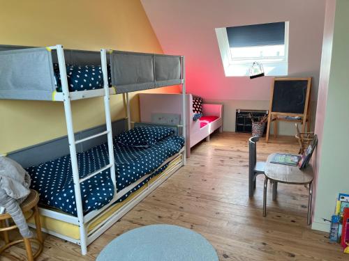 une chambre avec deux lits superposés et une table dans l'établissement Colora Cottage - A 100 m de la plage, à Portbail