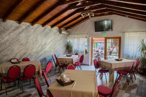a dining room with tables and chairs and a tv at Casa Majestic in Călimăneşti