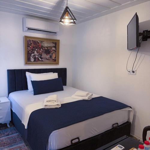 a bedroom with a bed with two towels on it at Hera Pansiyon in Ayvalık