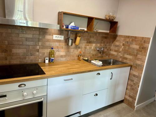 une cuisine avec des armoires blanches et un évier dans l'établissement Maison très proche des 24 Heures - 9 Personnes, à Laigné-en-Belin