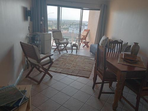 ein Wohnzimmer mit Stühlen und einem Tisch mit Aussicht in der Unterkunft The View No 21 in Jeffreys Bay