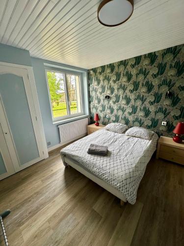 une chambre avec un lit dans une pièce aux murs bleus dans l'établissement Maison très proche des 24 Heures - 9 Personnes, à Laigné-en-Belin