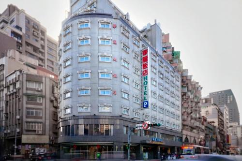 a tall building on a city street with buildings at 華麗大飯店Ferrary Hotel in Taipei
