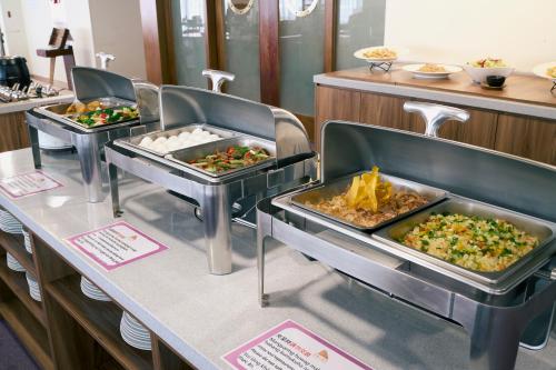 a buffet line with three trays of food at 華麗大飯店Ferrary Hotel in Taipei