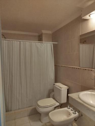 a bathroom with a white toilet and a sink at Brisas del Lago Apartamentos in Colón