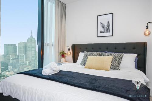 Ένα ή περισσότερα κρεβάτια σε δωμάτιο στο KozyGuru | Melbourne CBD 2Bed Apt + Stunning Views