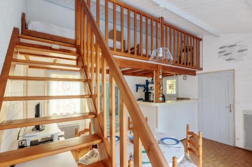 scala in legno in una camera con cucina di Maison aux Oiseaux - Welkeys a Dolus-d'Oléron