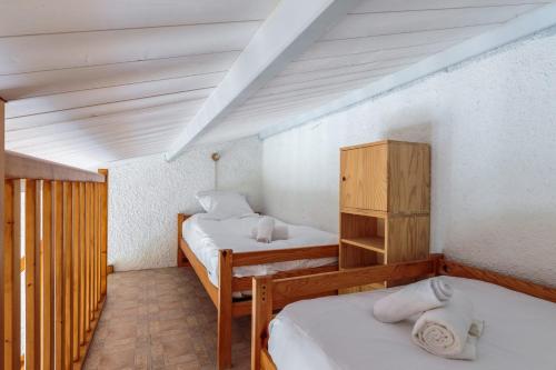 una camera con 2 letti e un armadio in legno di Maison aux Oiseaux - Welkeys a Dolus-d'Oléron
