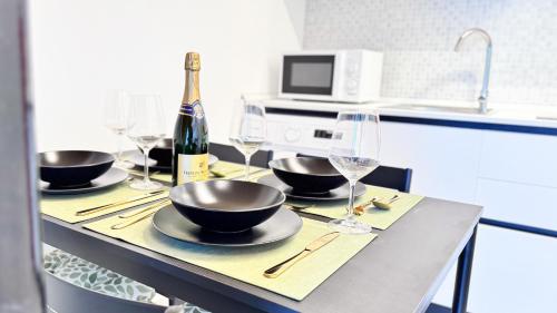 una mesa con tazones y copas y una botella de vino en Ca Teresa by Ca-Sa Check, en Chioggia