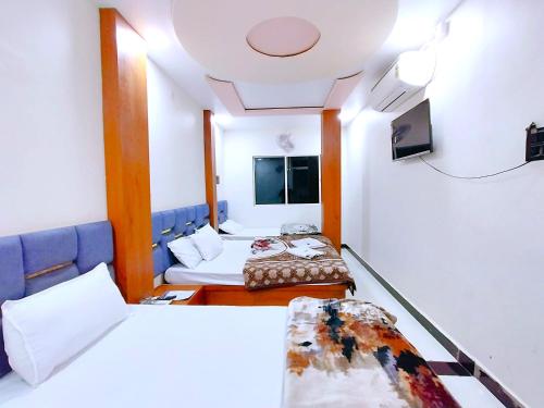 a hospital room with two beds and a tv at Hotel Shreem in Ujjain