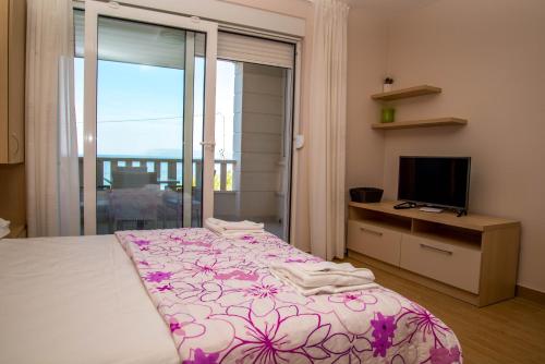 a bedroom with a large bed and a television at Waterfront Apartments - Tucepi in Tučepi