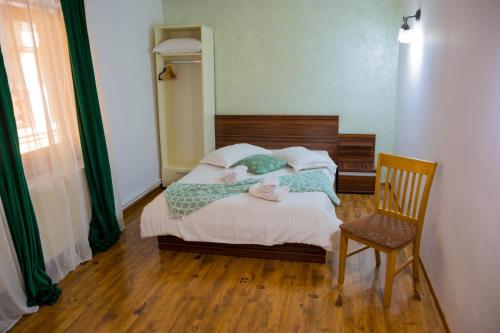 a small bedroom with a bed and a chair at Casa Majestic in Călimăneşti