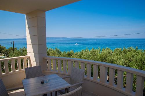 a balcony with a table and chairs and the ocean at Waterfront Apartments - Tucepi in Tučepi