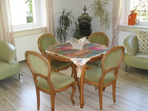 a dining room table with four chairs and a table and a table and chairsktop at Pension Rak in Karlovy Vary