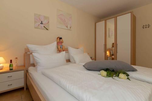 a bedroom with a large white bed with flowers on it at Ferienwohnung Plogmann - Residenz Bernstein WHG 39 in Rerik