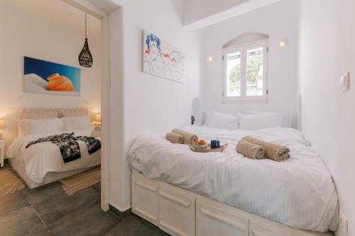 a white bedroom with a large bed with towels on it at Aegean Nest in Koskinou