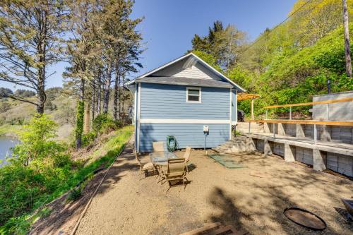 a small blue house with chairs and a table at Walk to Winema Road Beach Home with Hot Tub! in Cloverdale