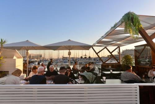 a group of people sitting at a restaurant with umbrellas at Villa Cove - Villa in complex only 5 minutes from the Marina of Vilamoura in Quarteira