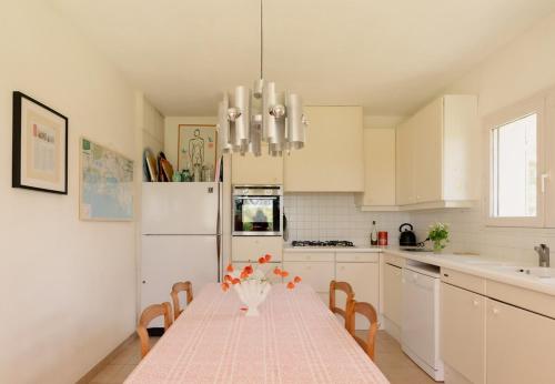 une cuisine avec une table avec un vase de fleurs dessus dans l'établissement La Maison blanche de Camargue, à Saintes-Maries-de-la-Mer