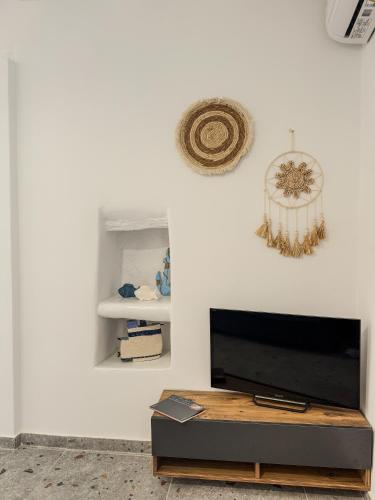 a living room with a flat screen tv on a white wall at Porto Gavrio Apartment in Gavrion