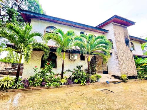 Minzi Homes في دار السلام: منزل أمامه أشجار نخيل