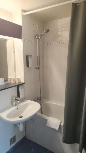 a bathroom with a sink and a bath tub and a sink at Hôtel Nell in Saint-Marcel