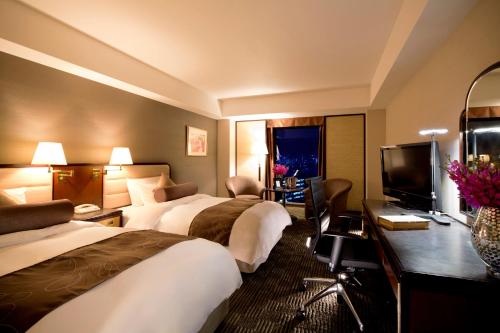 ein Hotelzimmer mit 3 Betten und einem TV in der Unterkunft ANA Crowne Plaza Hotel Kyoto by IHG in Kyoto